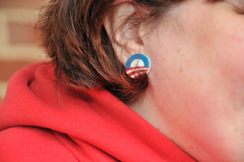 a woman is wearing a pair of patriotic earrings