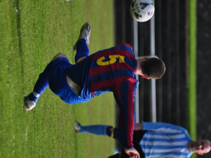 a soccer player kicks a ball during a game