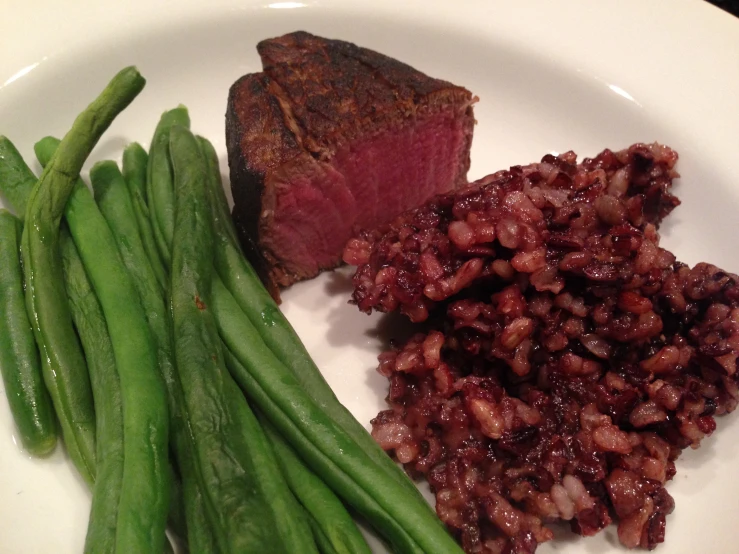 a dinner plate with meat, beans, and green beans