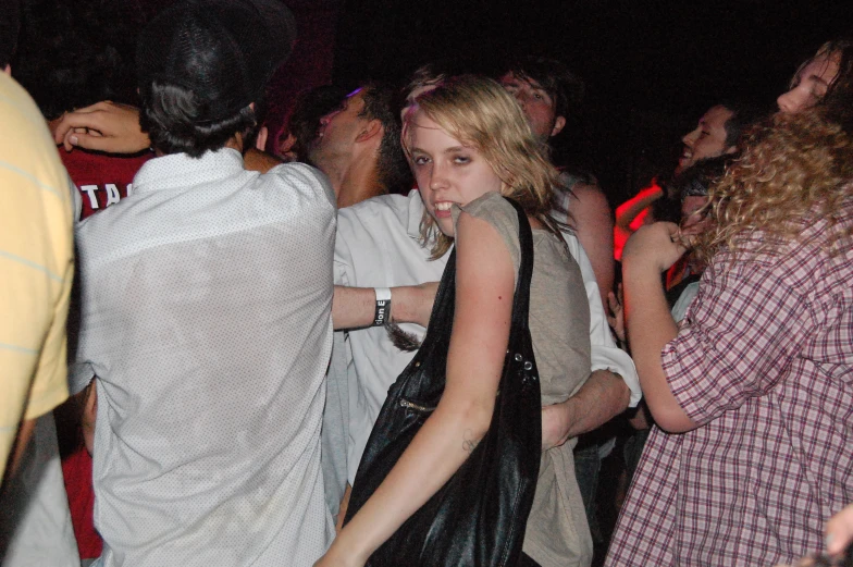 a girl in a leather purse dancing with other people