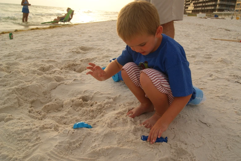 two children play on the sand at a beach