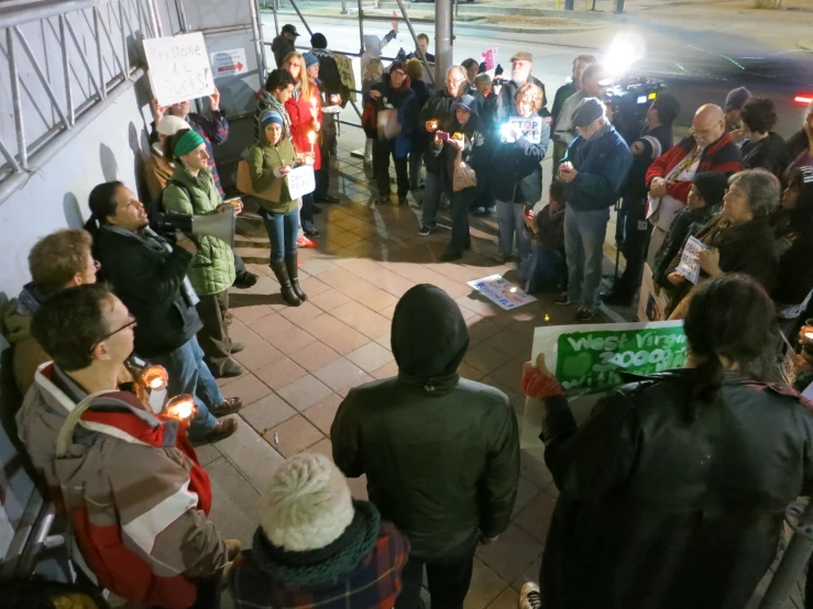 a group of people are standing near each other holding signs