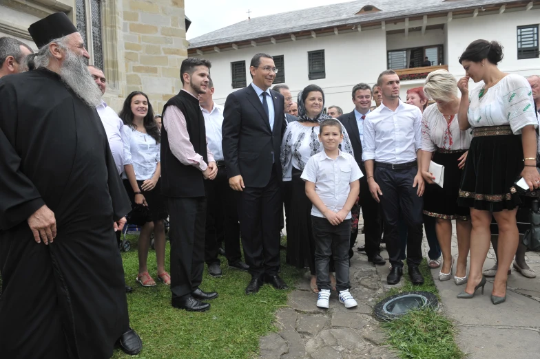 a man in a suit and tie standing next to a little girl