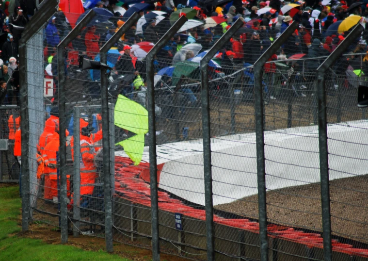 a crowd of people gathered near an event fence