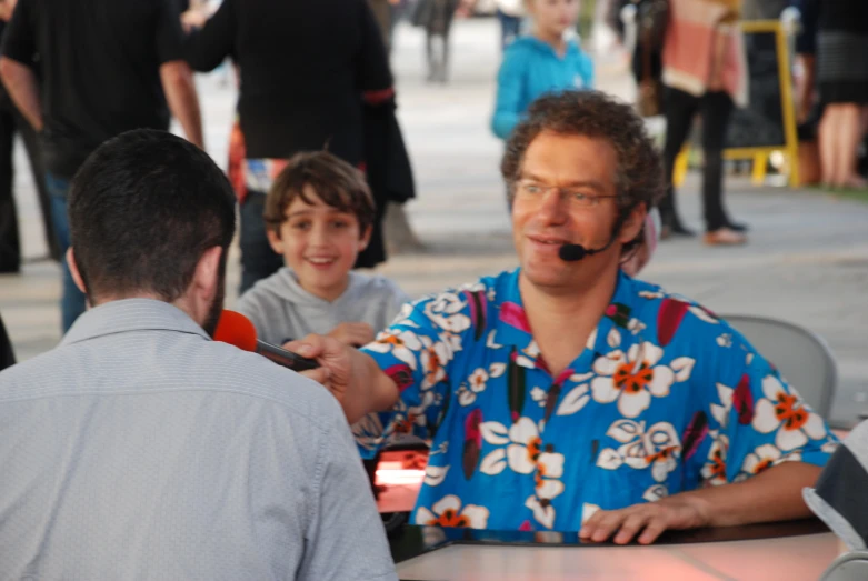 a man with a headset at an outdoor table