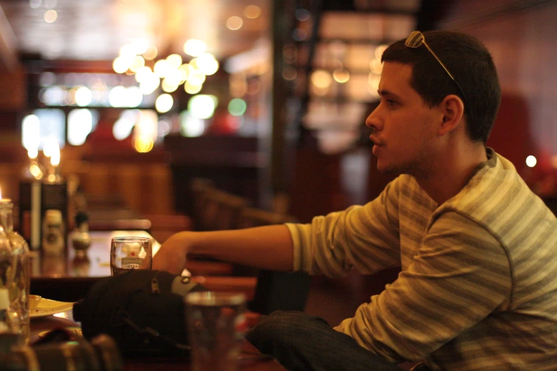 a man sitting at a table in front of glasses