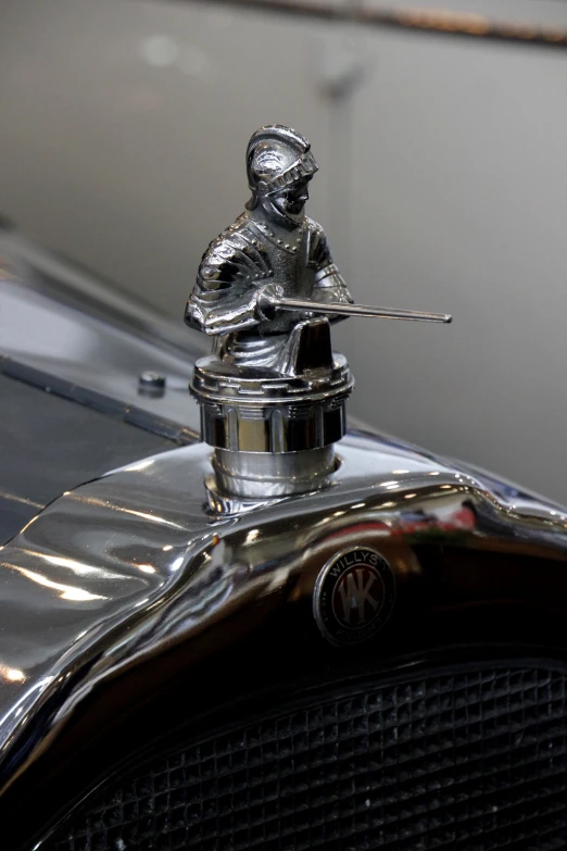 a chrome figure sits atop a silver car