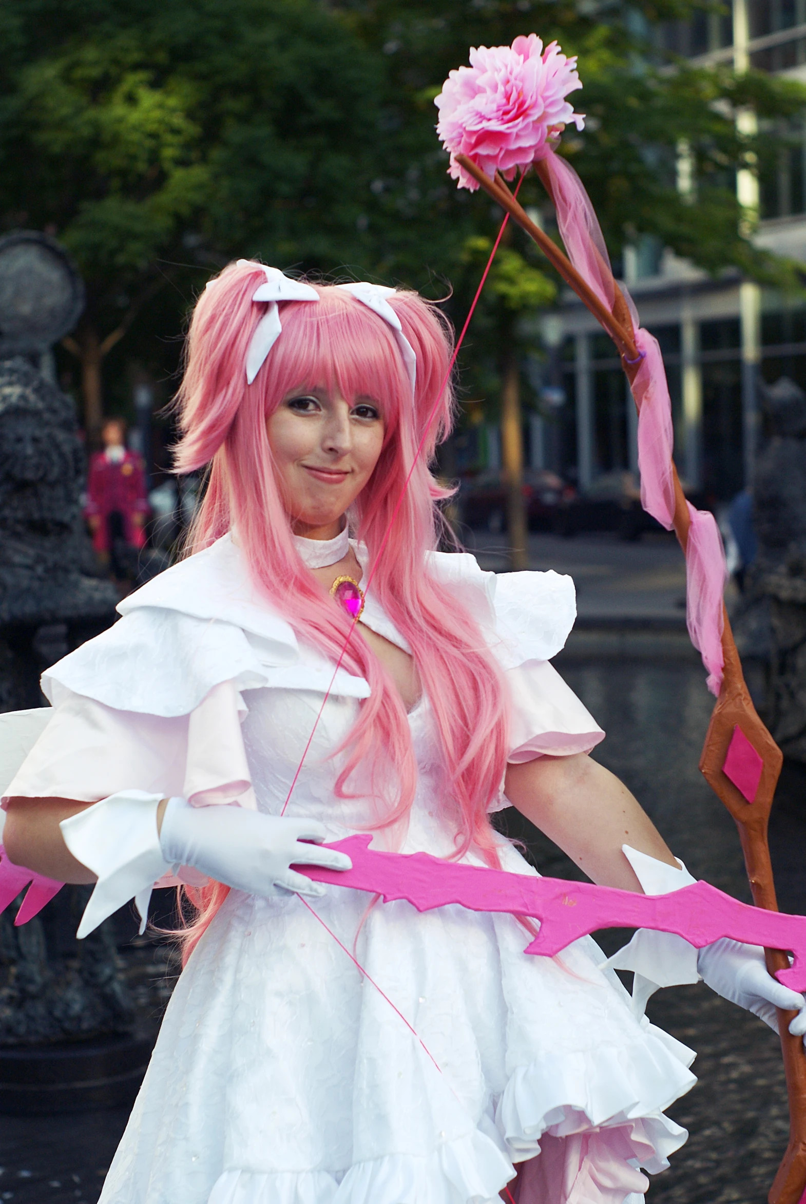 a pink haired woman with a long pink ribbon around her arm