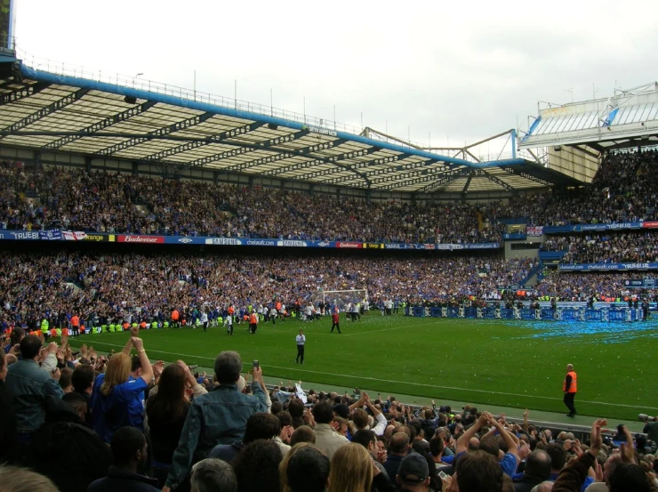 soccer fans are sitting in the stadium and on the field