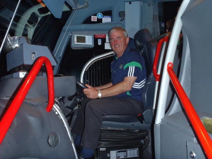 the man is seated on the airplane and smiling