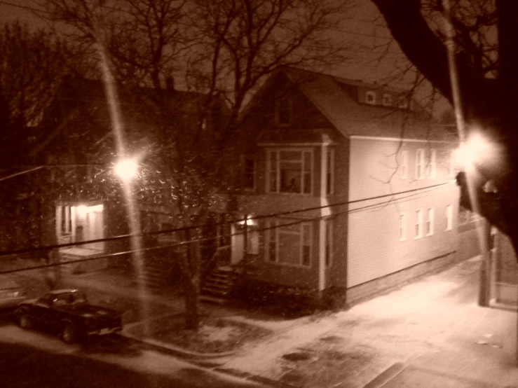 a dark picture of a street with a car and building