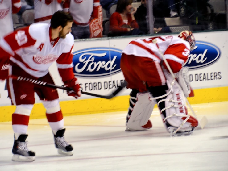 two men on the ice in red and white uniforms