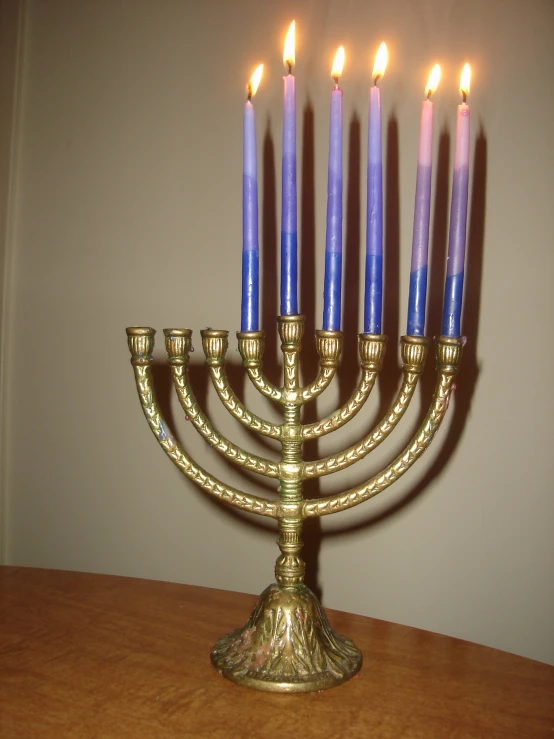 a large gold menorah with six lit candles