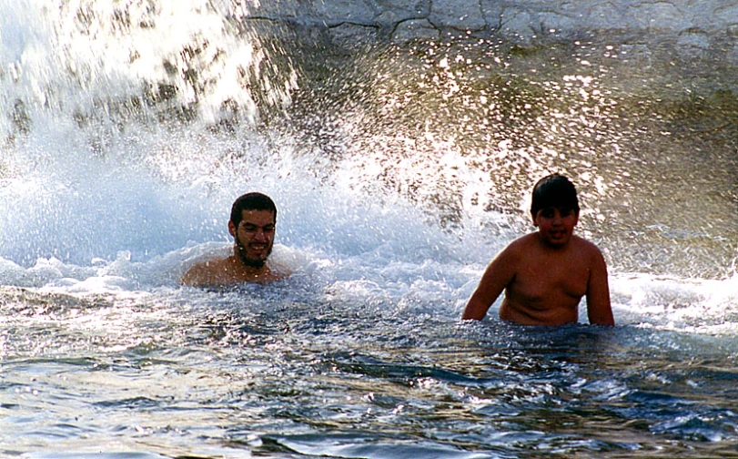 the two men are in the water surfing