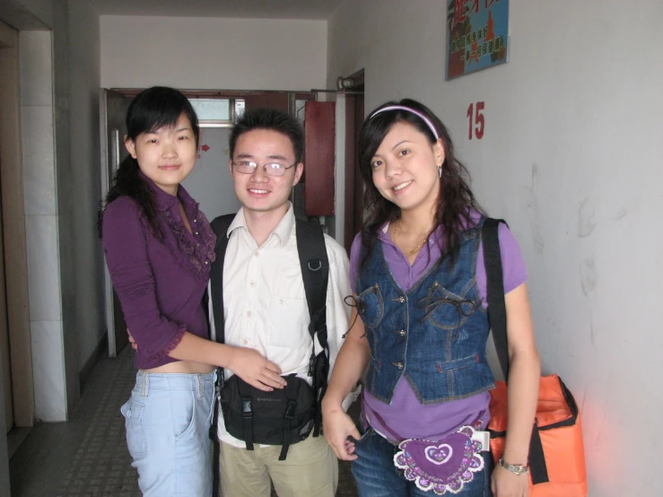 three people in a hallway posing for the camera