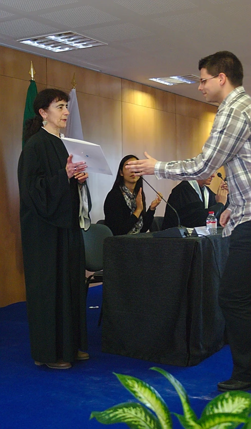 a man and woman are exchanging gifts at an event