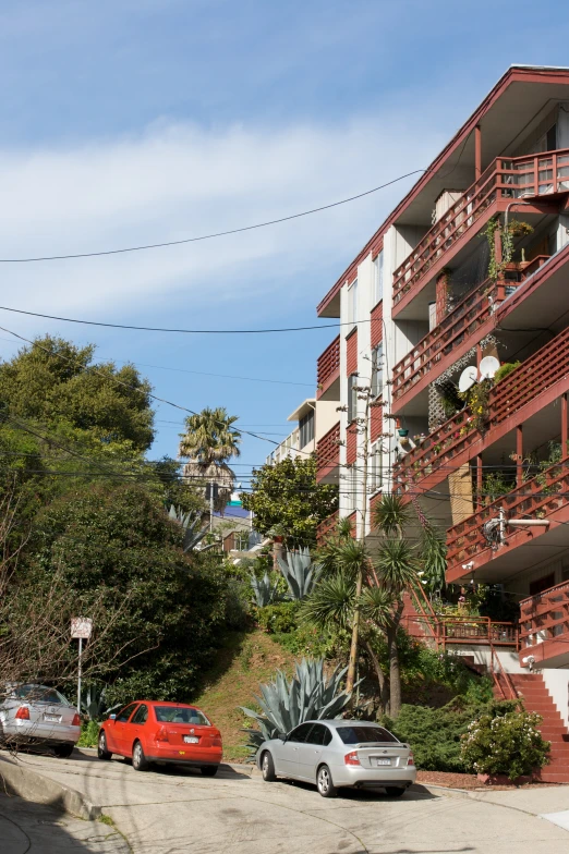 an apartment building with two cars parked in front