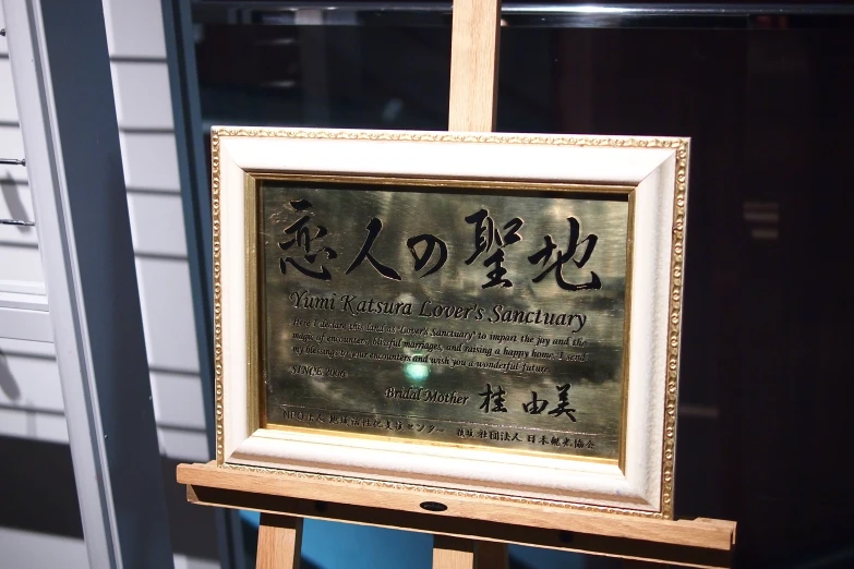 a gold framed calligraphy displayed in a frame