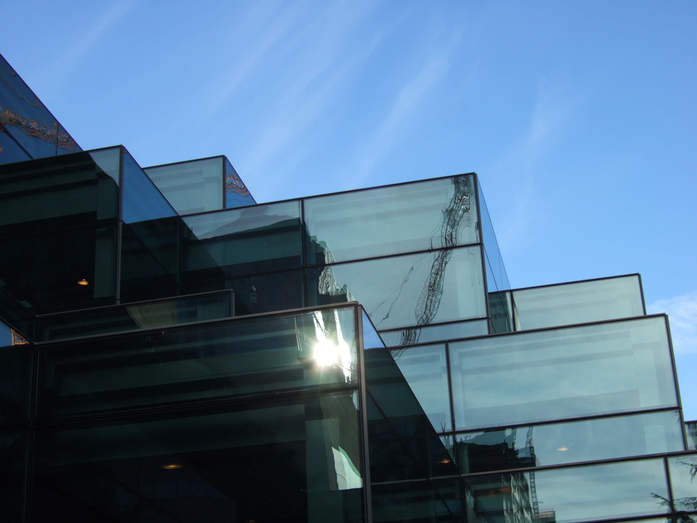 the sky behind several glass buildings with the light shining