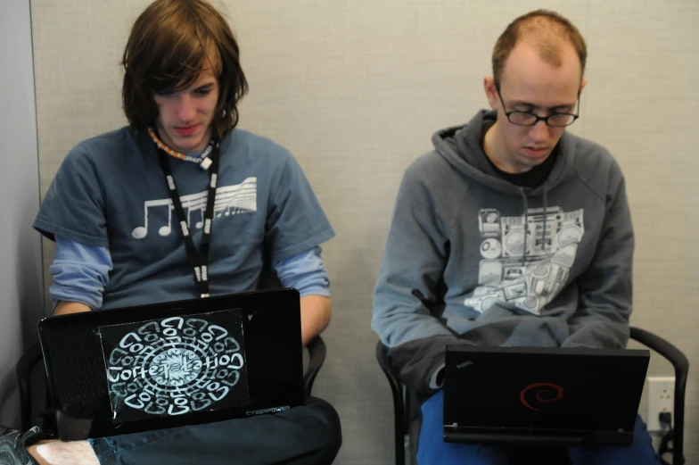 two men sitting down and using their computers