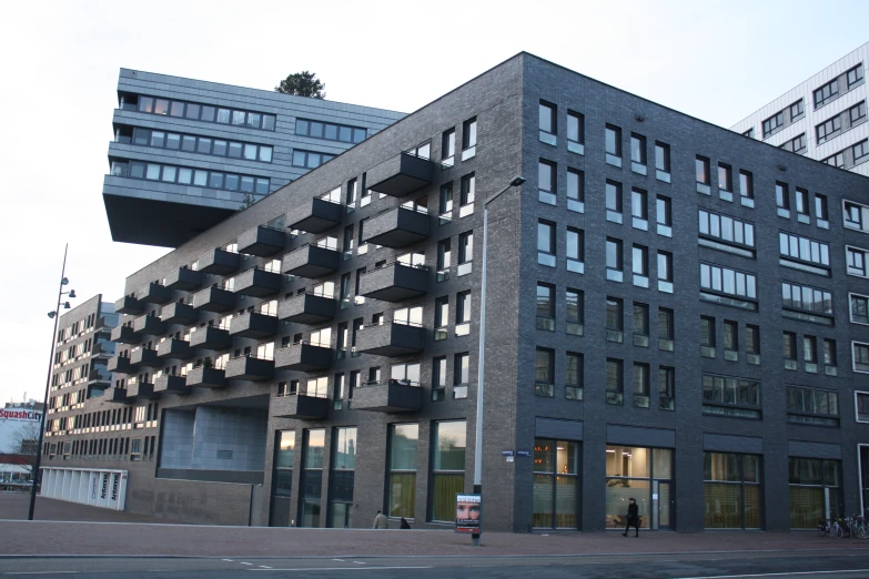 a tall black brick building on a street