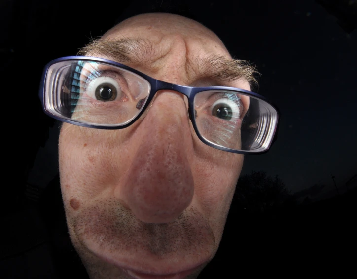 a man with glasses looking up into the air