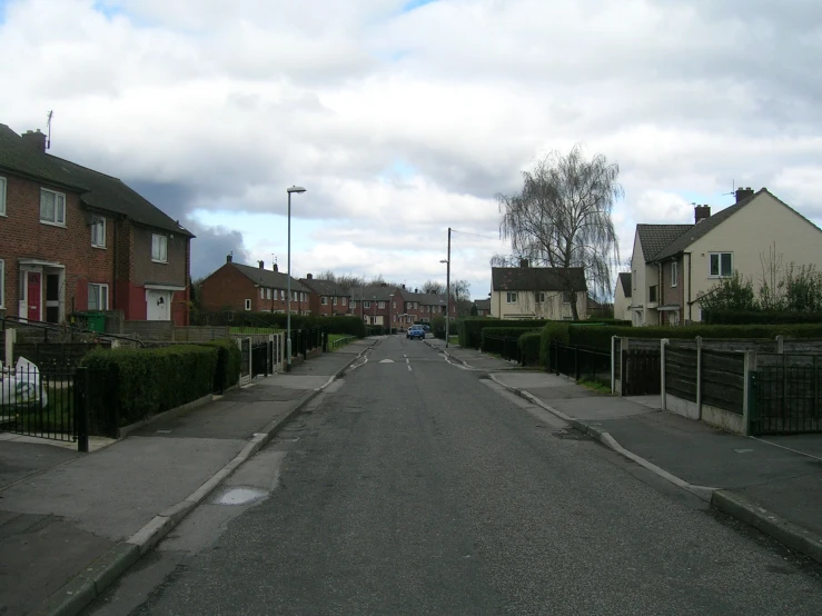 two cars driving down the street in the middle of residential homes