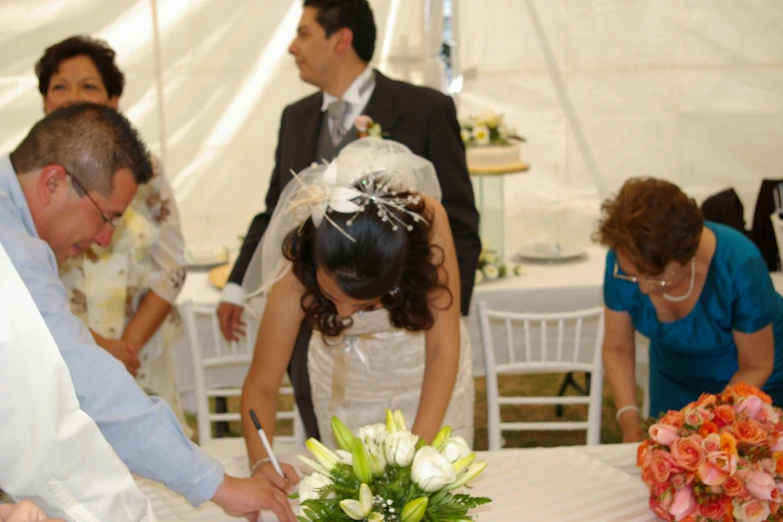 the bride and groom are  their wedding cake