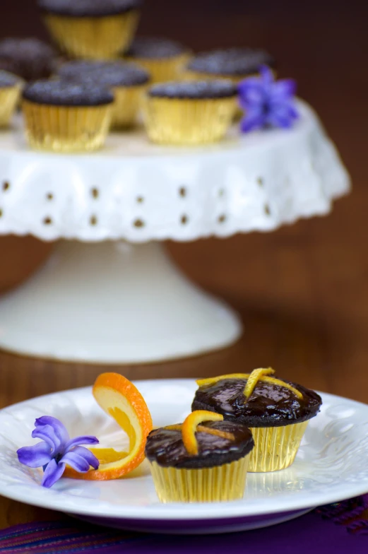 a tray of freshly made orange and chocolate cupcakes