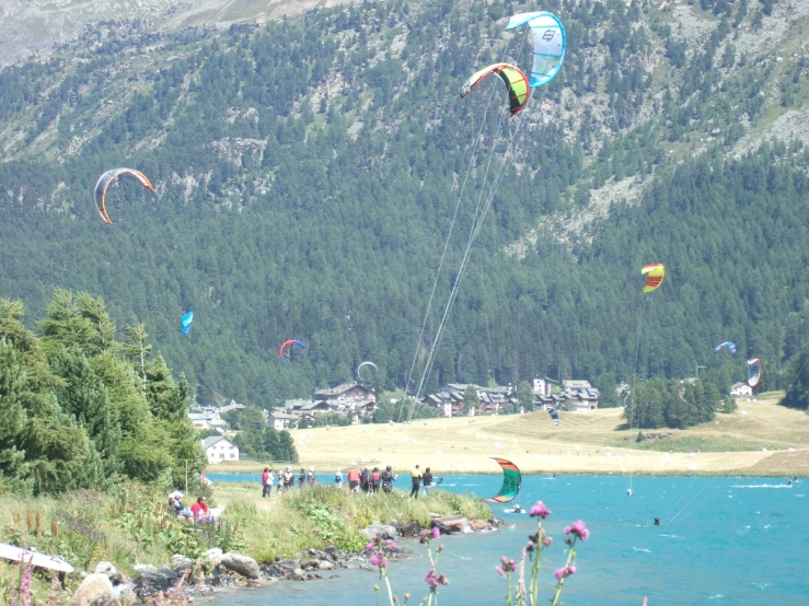 people are parasailing over the water and on shore