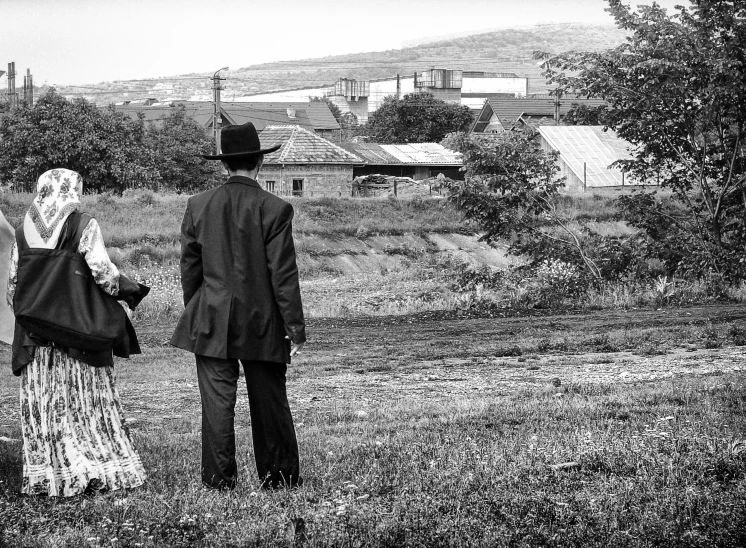 two people standing in a field holding hands