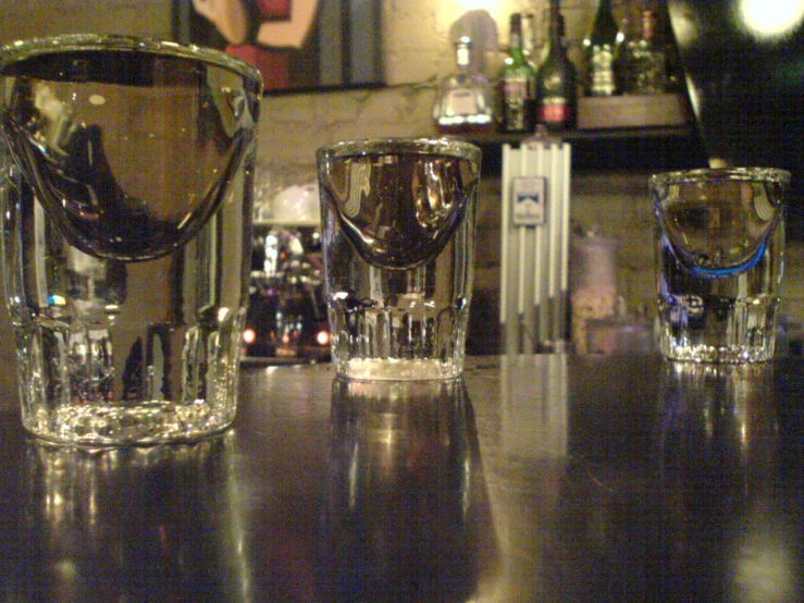 two glasses with water on top of a wooden table