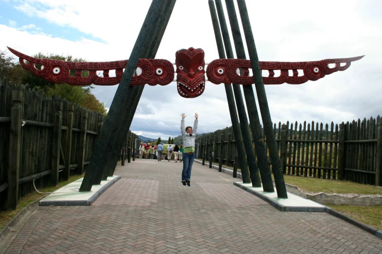 a person walking up a path under a red sculpture