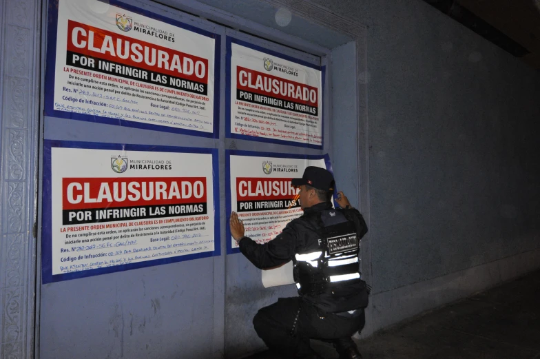 a cop standing in front of posters holding signs