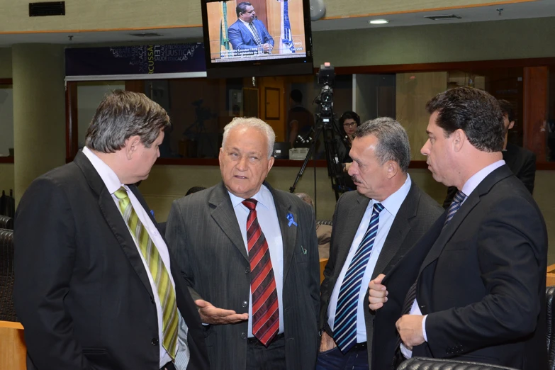 four men standing in front of a flat screen tv