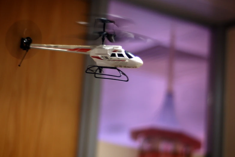 a toy helicopter is flying above a wooden door