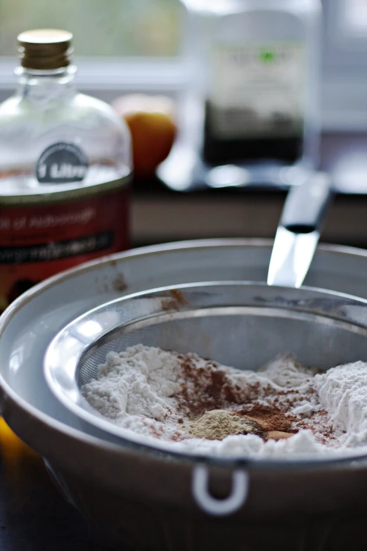 a metal bowl filled with white powder sitting on top of a table