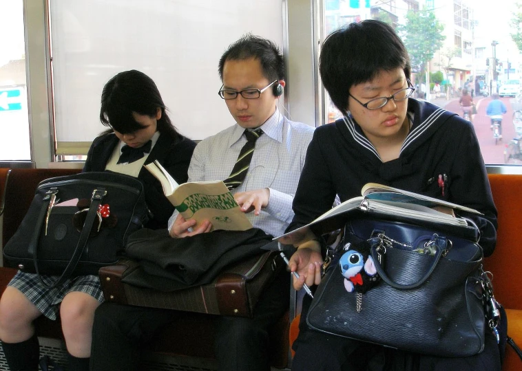 four people on the seat and looking at a book
