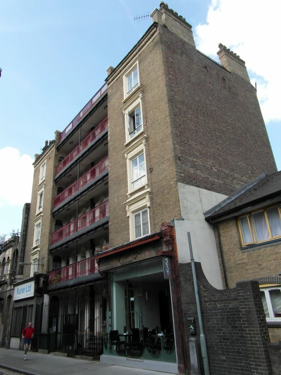 a tall brown brick building with balconies on it