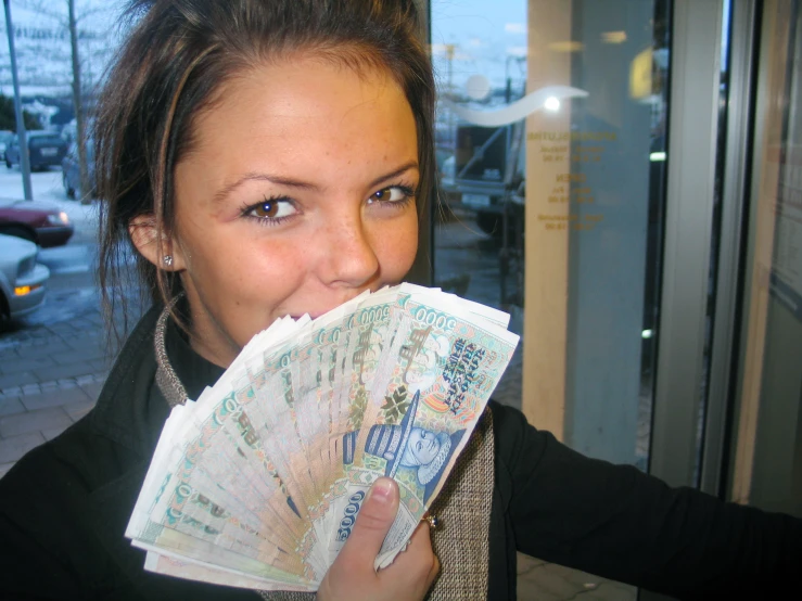 a woman taking a big bite of the money