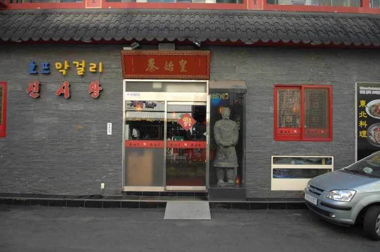 a man stands outside a restaurant near a car