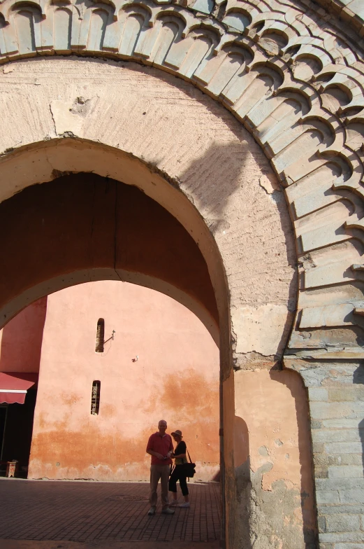 a couple of people are standing under a arch