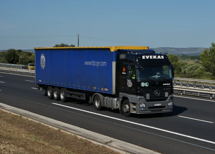 the big rig truck is driving along the highway