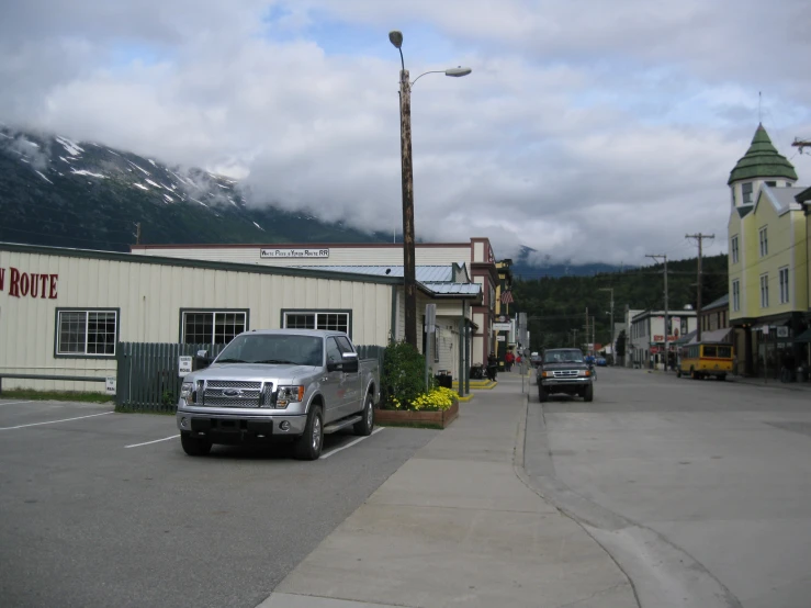 a silver truck sits parked in front of a mountain restaurant