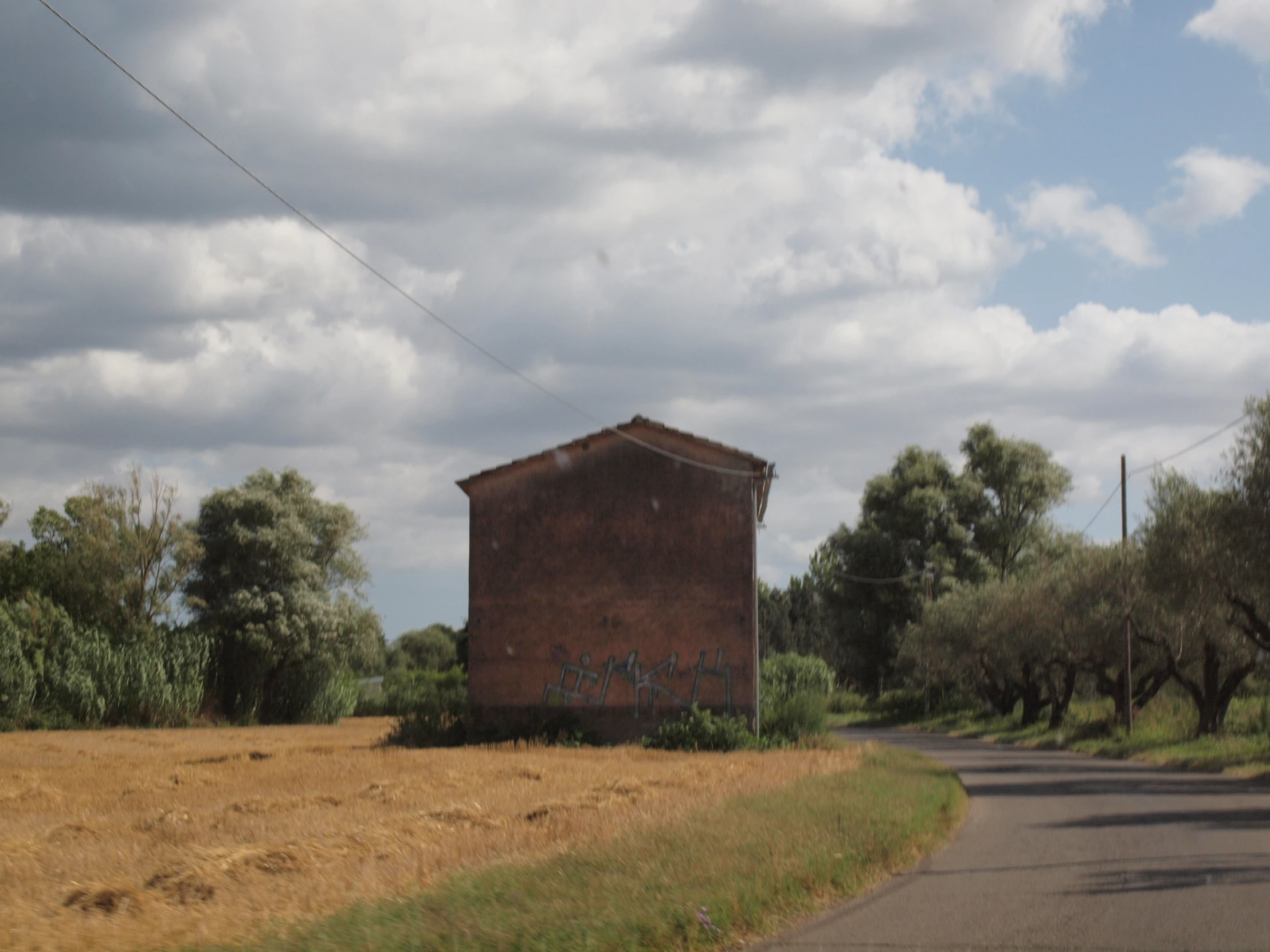 a big old brick building sitting in the middle of a country side road