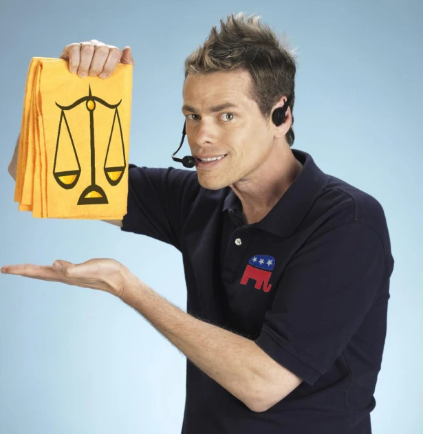 a man holding up a yellow bag with the scale of justice on it