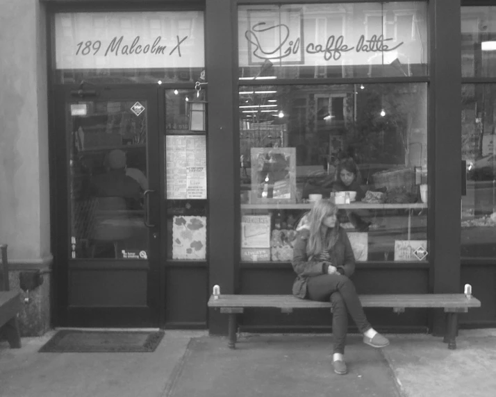 a person sitting on a bench outside of a store