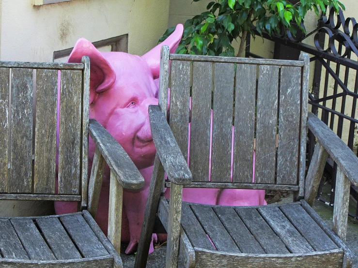 a pink pig in a chair next to another chair