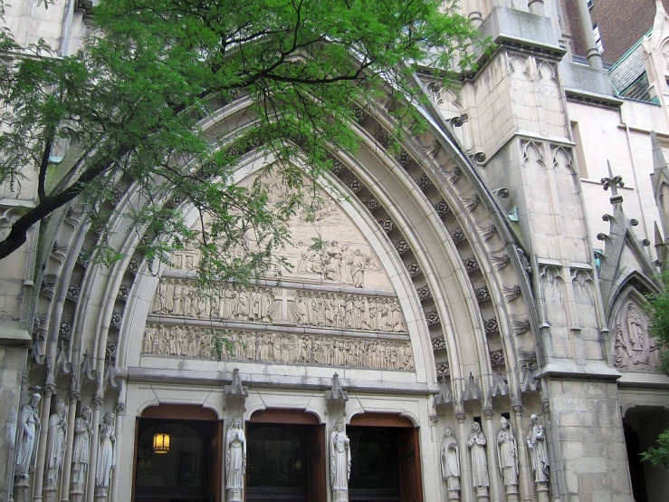 this building has a stone archway with statues of lions and cats on it