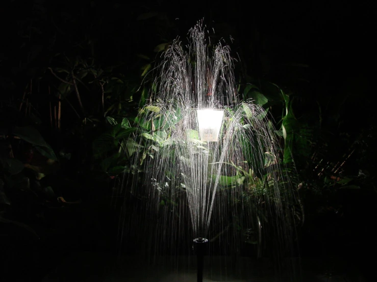 a large waterfall is spewing water in the dark